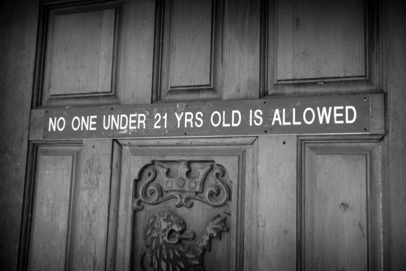 Door with sign saying NO ONE UNDER 21 YRS OLD IS ALLOWED