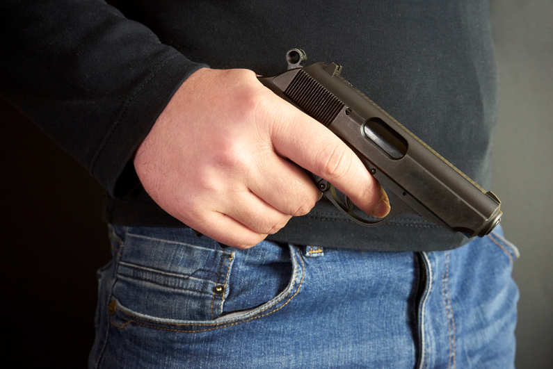 male holding a handgun