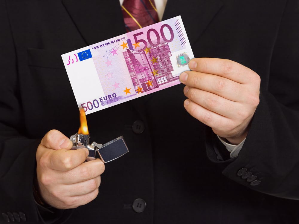 businessman setting fire to 500 euro note