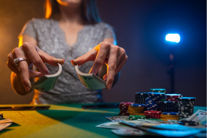 woman shuffling cards at a poker table