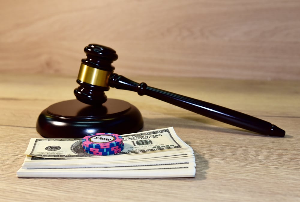 Wooden gavel with dollars and poker chips